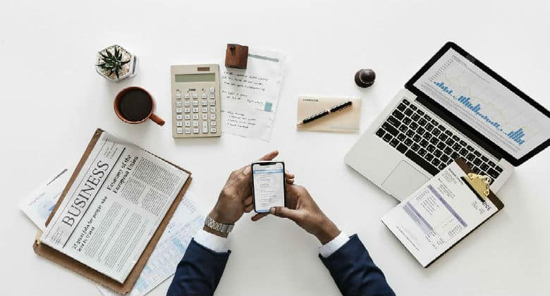 Business man surrounding by office supplies on desk