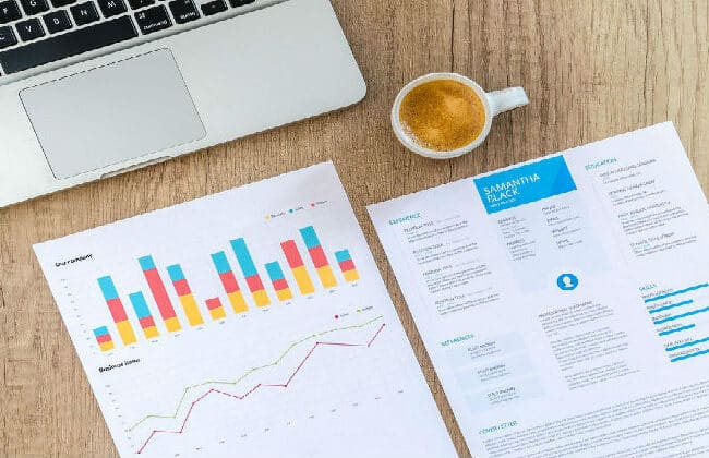 Espresso sitting on table with graphs on pages