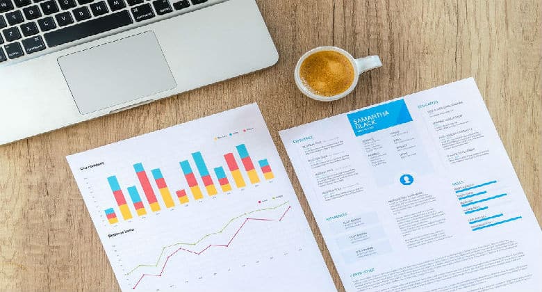 Espresso sitting on table with graphs on pages