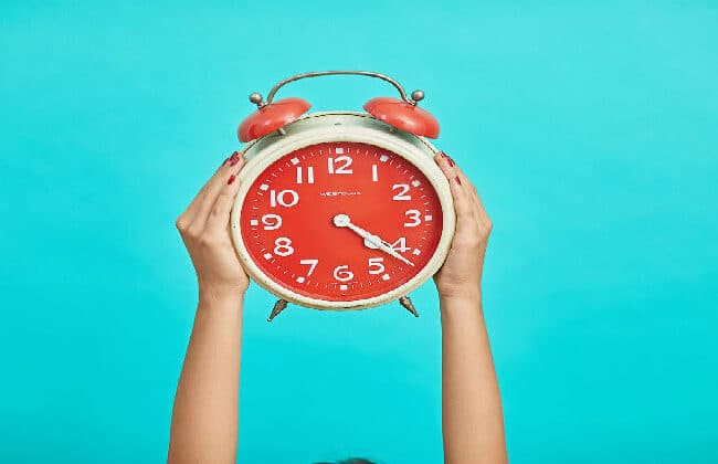 Woman holding up a clock