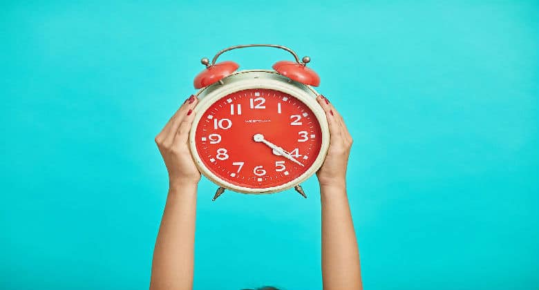 Woman holding up a clock