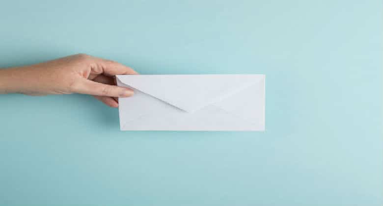 A hand giving an envelope away