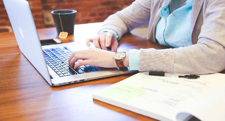 Woman working on laptop and a note pad