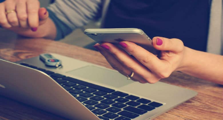 Woman working on laptop & cellphone