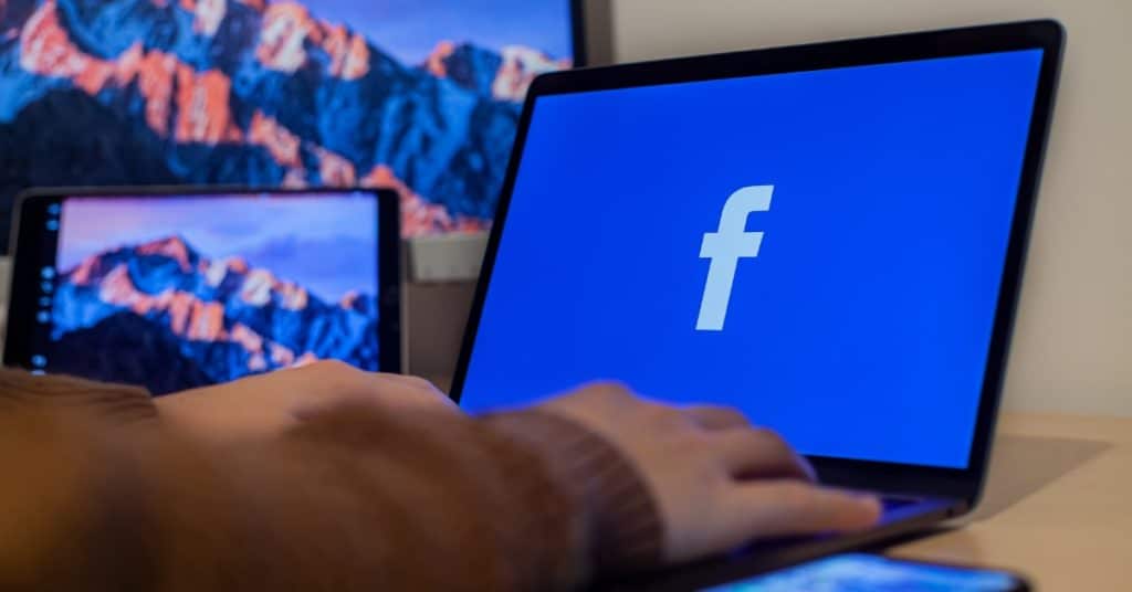 Facebook open on laptop with background image of mountains