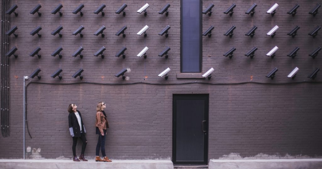 Two women looking up at a multitude of cameras pointing at them 